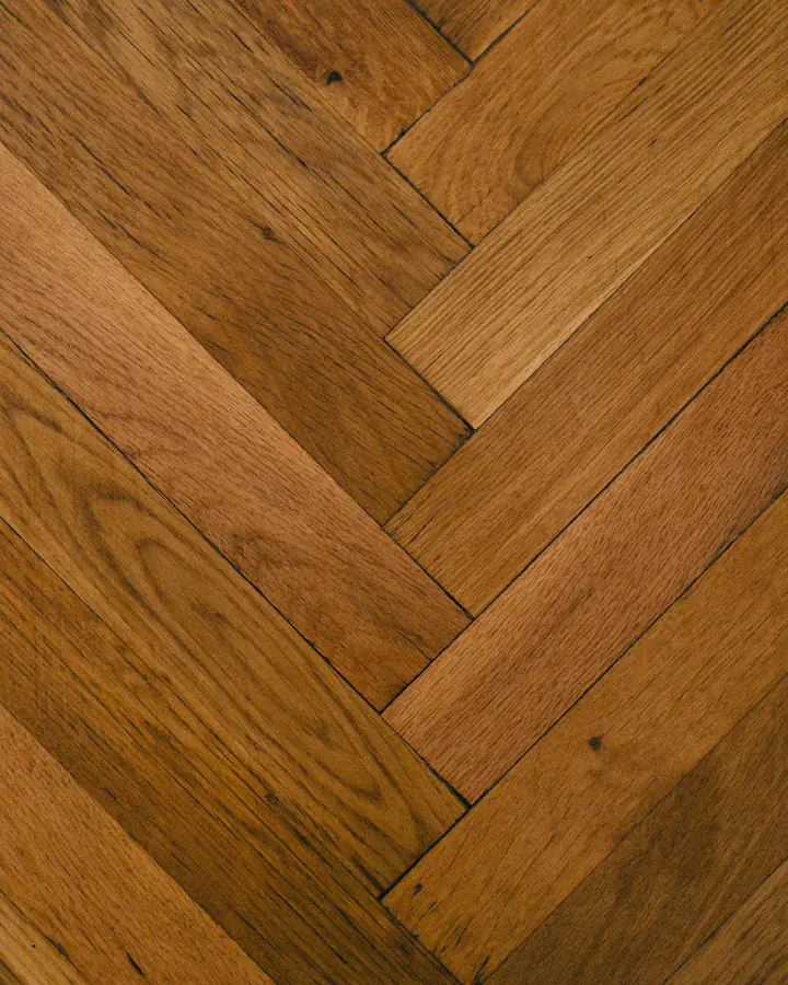 Photo d’illustration : un parquet en chêne posé à bâtons rompus, lames saines et joints serrés.